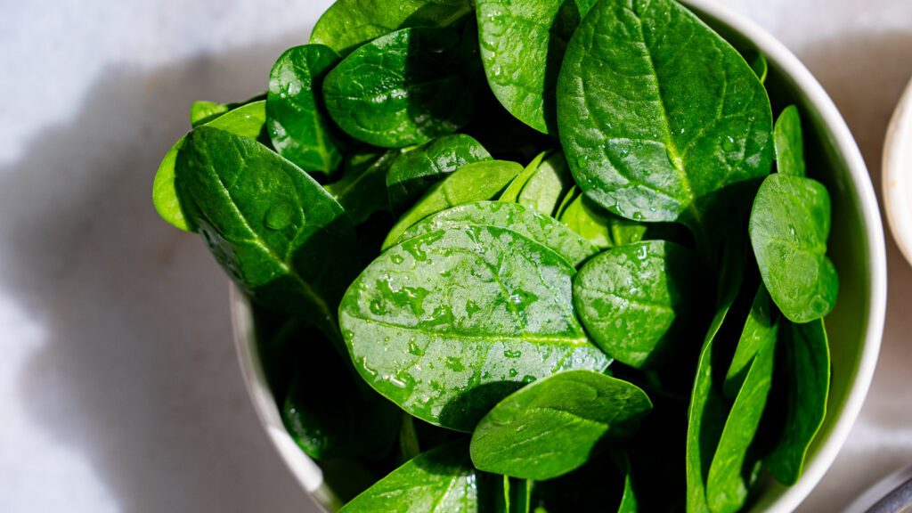 Fresh baba spinach in a light-colored bowl.