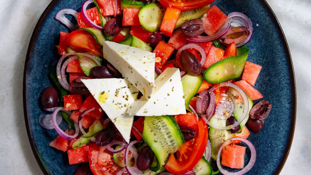 Ensalada griega con sandía servida en plato.