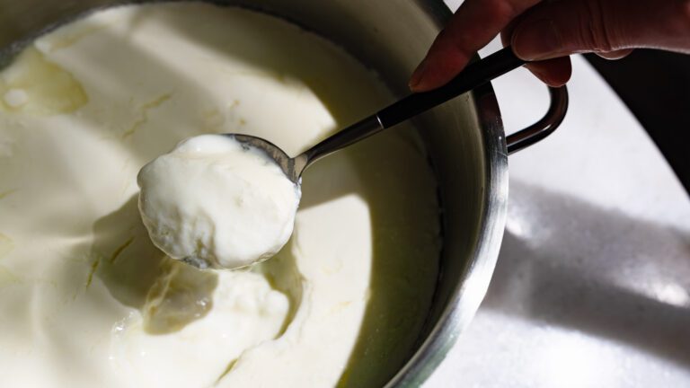 Make your own yogurt: homemade yogurt is scooped out of a pot with a spoon.