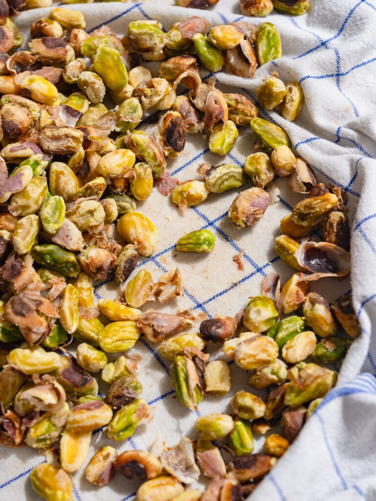 Blanched pistachios are on a kitchen towel.