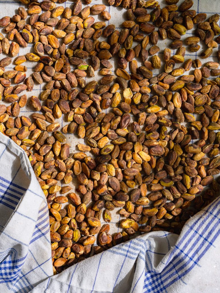 Roasted pistachios lie on a kitchen towel.